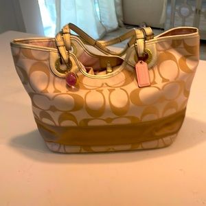 Coach authentic gold purse with pink lining.